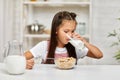 Cute little girl eating breakfast: cereal with the milk Royalty Free Stock Photo