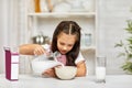 Cute little girl eating breakfast: cereal with the milk Royalty Free Stock Photo