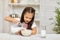 Cute little girl eating breakfast: cereal with the milk Royalty Free Stock Photo