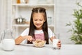 Cute little girl eating breakfast: cereal with the milk Royalty Free Stock Photo