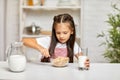 Cute little girl eating breakfast: cereal with the milk Royalty Free Stock Photo