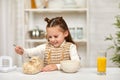 Cute little girl eating breakfast: cereal and orange juice Royalty Free Stock Photo