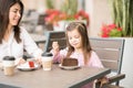 Little girl having cake with mother at cafe Royalty Free Stock Photo
