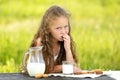 Cute little girl eating chocolate chip cookie on green background