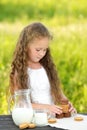 Cute little girl eating chocolate chip cookie on green background Royalty Free Stock Photo