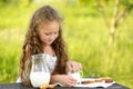 Cute little girl eating chocolate chip cookie on green background Royalty Free Stock Photo