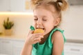 Cute little girl eating cookies in kitchen Royalty Free Stock Photo