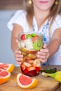 Cute little girl eating healthy fruit salad in the kitchen at home Cute little girl cooking in the kitchen. Healthy food concept. Royalty Free Stock Photo