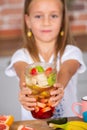 Cute little girl eating healthy fruit salad in the kitchen at home Cute little girl cooking in the kitchen. Healthy food concept. Royalty Free Stock Photo