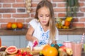 Cute little girl eating healthy fruit salad in the kitchen at home Cute little girl cooking in the kitchen. Healthy food concept. Royalty Free Stock Photo