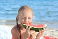 Cute little girl eating juicy watermelon on beach Royalty Free Stock Photo