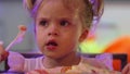 cute little girl eating a piece of cake on a paper plate with a plastic fork. Royalty Free Stock Photo