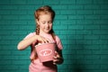 Cute little girl eating popcorn against brick wall Royalty Free Stock Photo