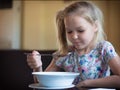 Cute little girl eating soup in the restaurant Royalty Free Stock Photo