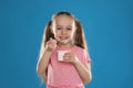 Cute little girl eating tasty yogurt on background Royalty Free Stock Photo