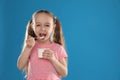 Cute little girl eating tasty yogurt on background. Space for text Royalty Free Stock Photo