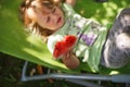 Cute little girl eating watermelon on a deck chair in the garden in summertime Royalty Free Stock Photo