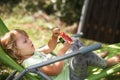 Cute little girl eating watermelon on a deck chair in the garden in summertime Royalty Free Stock Photo