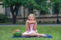 Cute little girl eating watermelon on the grass in summer time. with ponytail long hair and toothy smile sitting on grass and enjo Royalty Free Stock Photo