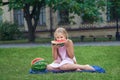 Cute little girl eating watermelon on the grass in summer time. with ponytail long hair and toothy smile sitting on grass and enjo Royalty Free Stock Photo