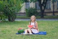 Cute little girl eating watermelon on the grass in summer time. with ponytail long hair and toothy smile sitting on grass and enjo Royalty Free Stock Photo