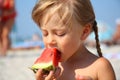 Cute little girl eating watermelon in summertime