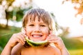 Cute little girl eating watermelon in sunny summer garden Royalty Free Stock Photo