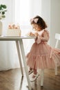 Cute little girl eats a birthday cake with a spoon on her birthday Royalty Free Stock Photo