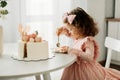 Cute little girl eats a birthday cake with a spoon on her birthday Royalty Free Stock Photo