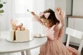 Cute little girl eats a birthday cake with a spoon on her birthday Royalty Free Stock Photo