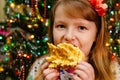 cute little girl eats cake sakotis new year and merry christmas background Royalty Free Stock Photo