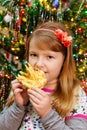 cute little girl eats cake sakotis new year and merry christmas background Royalty Free Stock Photo