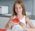 Cute little girl eats a watermelon in the kitchen Royalty Free Stock Photo
