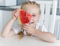 Cute little girl eats a watermelon in the kitchen Royalty Free Stock Photo