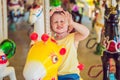 Cute little girl enjoying in funfair and riding on colorful carousel house Royalty Free Stock Photo