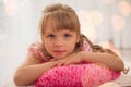 Cute little girl enjoying lying on the floor at home.