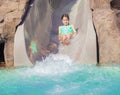 Cute little girl enjoying a wet ride down a water slide Royalty Free Stock Photo