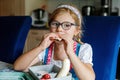 Cute Little Girl with Eyeglasses Eating Sandwich and Fruits during Break between Classes. Healthy Unhealthy Food for Kid Royalty Free Stock Photo