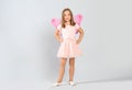 Cute little girl in fairy costume with pink wings and magic wand on light background Royalty Free Stock Photo