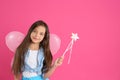 Cute little girl in fairy costume with wings and magic wand on pink background. Space for text Royalty Free Stock Photo