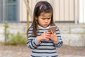 Cute little girl fascinated by a mobile phone