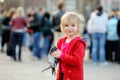 Cute little girl feeding and chasing birds on Dam Square in Amsterdam on summer day