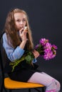 Cute little girl with flowers in her hands retrieves bird trill with bird whistle Royalty Free Stock Photo