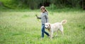 Cute little girl with flowers walking dog Royalty Free Stock Photo