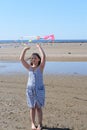 Cute little girl flying rainbow kite on sea beach Royalty Free Stock Photo