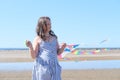 Cute little girl flying rainbow kite on sea beach Royalty Free Stock Photo