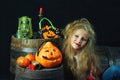 Cute little girl in the form of a witch with pumpkins