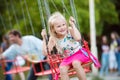 Cute little girl at fun fair, chain swing ride Royalty Free Stock Photo