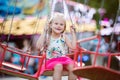 Cute little girl at fun fair, chain swing ride Royalty Free Stock Photo