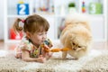 Cute little girl and funny dog at home